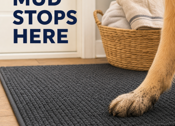 Muddy golden retriever paw resting on a textured charcoal doormat beside a towel basket.